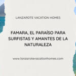 Surfistas en Playa de Famara, Lanzarote, con el Risco de Famara y paisaje natural volcánico.